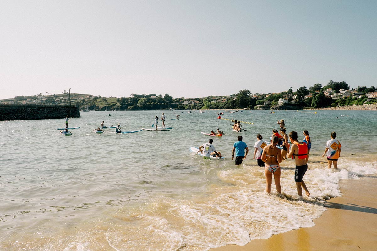 Grupo de persoas participando en actividades de voluntariado na praia.